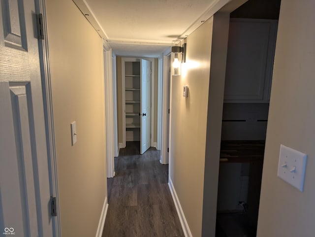 corridor with dark wood-type flooring and baseboards