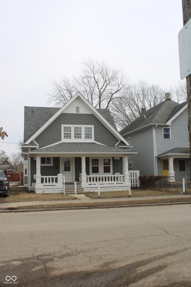 view of front of house featuring covered porch and a shingled roof