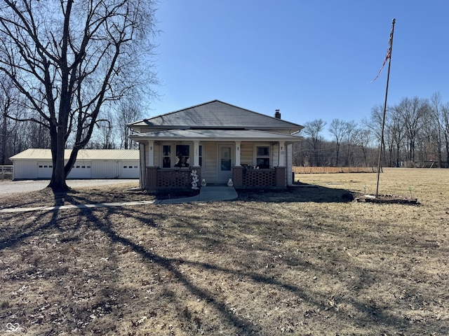 view of front of house with covered porch, a front yard, and a garage