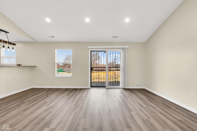 unfurnished room featuring recessed lighting, wood finished floors, and baseboards