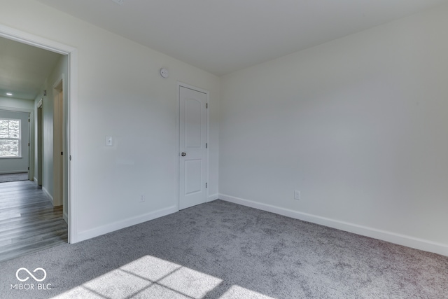 carpeted spare room with baseboards