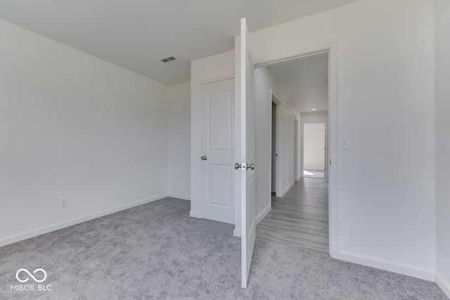 unfurnished bedroom with carpet floors, visible vents, and baseboards