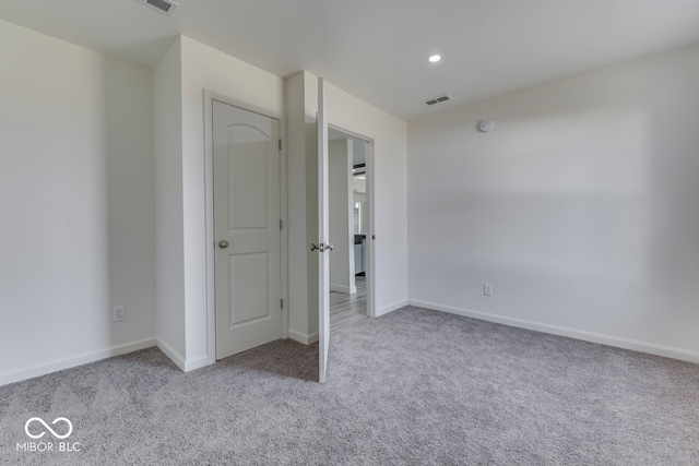 unfurnished bedroom with carpet, visible vents, and baseboards