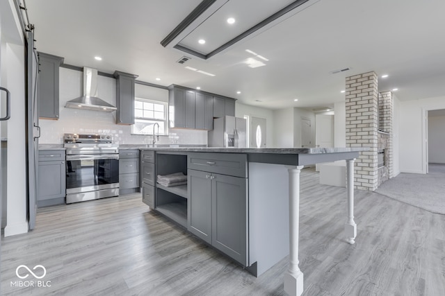 kitchen with stainless steel appliances, gray cabinets, visible vents, and wall chimney range hood