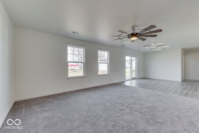 unfurnished room with light carpet, ceiling fan, visible vents, and baseboards