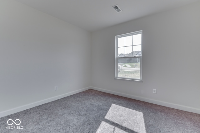 carpeted spare room featuring visible vents and baseboards