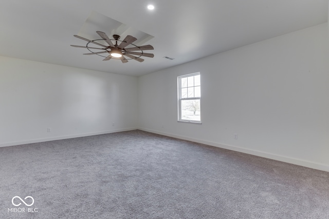 empty room with carpet, ceiling fan, visible vents, and baseboards