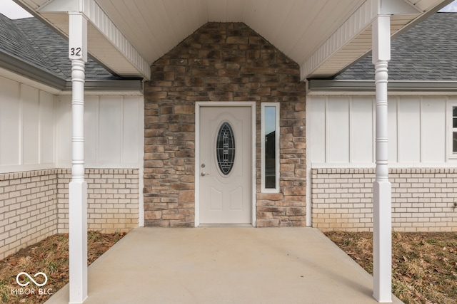 doorway to property featuring a shingled roof and board and batten siding