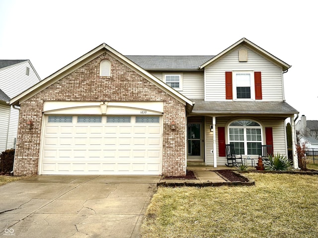 traditional-style house with brick siding, a porch, concrete driveway, an attached garage, and a front lawn