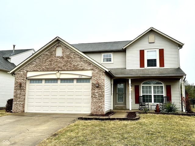 traditional-style home featuring a garage, driveway, a shingled roof, a front lawn, and brick siding