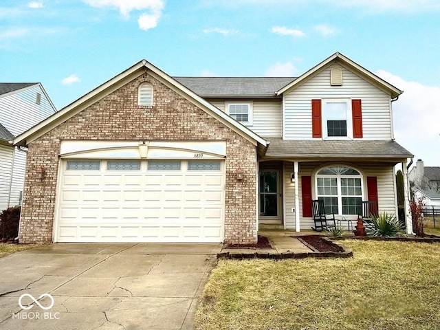 traditional home with a front lawn, driveway, a porch, a garage, and brick siding