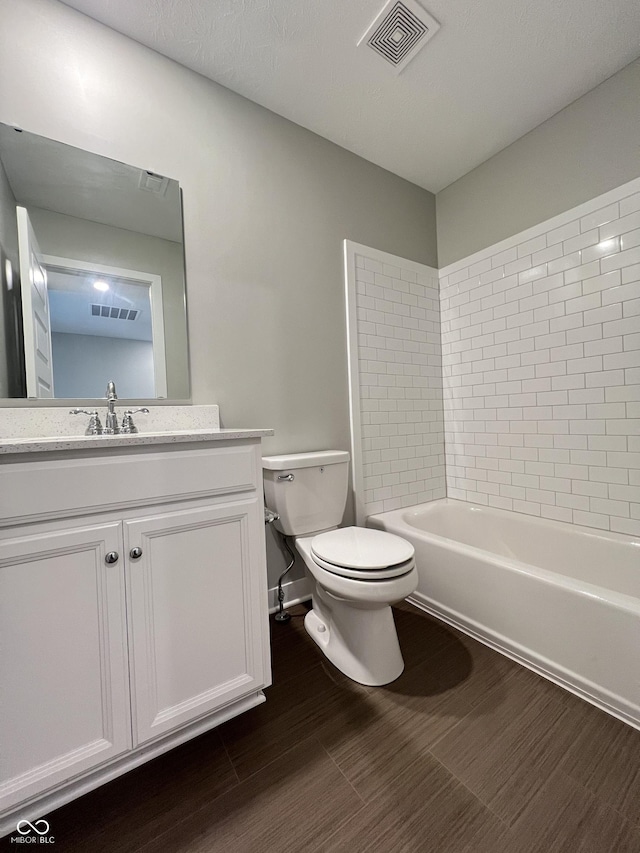 full bath featuring toilet, wood finished floors, and visible vents