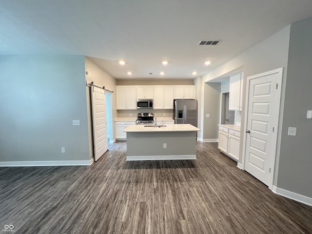 kitchen featuring a barn door, visible vents, stainless steel appliances, and light countertops