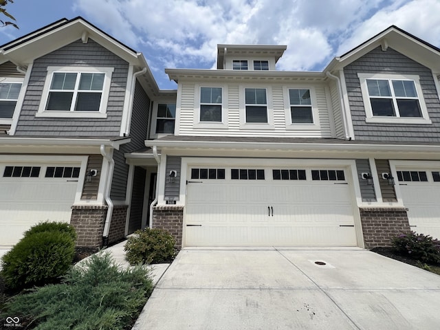 view of front of home with a garage, driveway, and brick siding