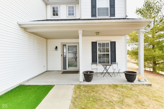 property entrance featuring a yard and a patio