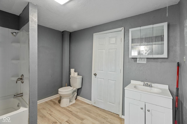 full bath featuring baseboards, toilet, wood finished floors, vanity, and shower / washtub combination