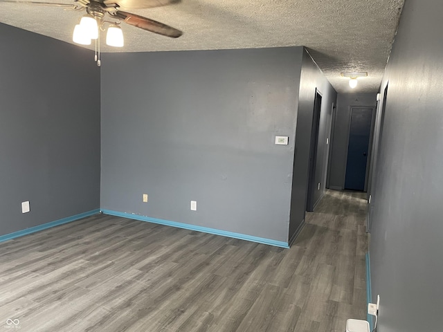 empty room featuring wood finished floors, a ceiling fan, baseboards, and a textured ceiling