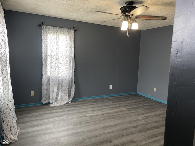 spare room with a textured ceiling, wood finished floors, and a ceiling fan