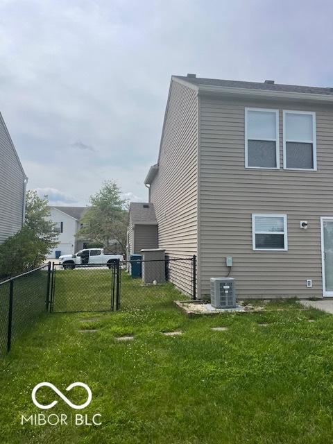 8249 Retreat Ln, Indianapolis, IN 46259 - view of side of home with a gate, central AC unit, fence, and a yard