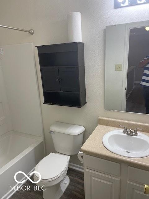 8249 Retreat Ln, Indianapolis, IN 46259 - bathroom featuring wood finished floors, toilet, vanity, and shower / bathtub combination