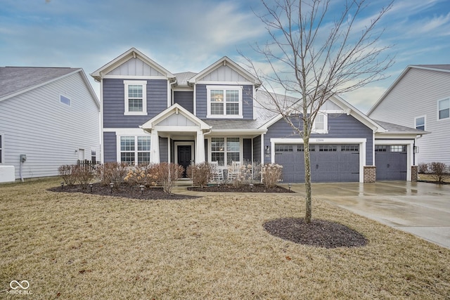 craftsman-style home with a garage, covered porch, concrete driveway, board and batten siding, and a front yard