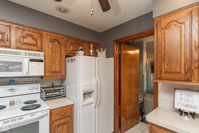 kitchen with brown cabinets, white appliances, and light countertops