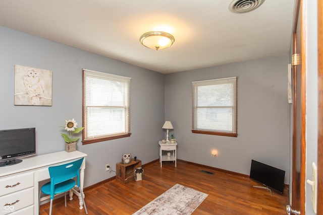 office area featuring dark wood-style flooring, visible vents, and baseboards