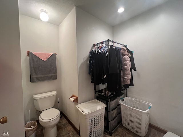 bathroom featuring toilet, baseboards, and recessed lighting