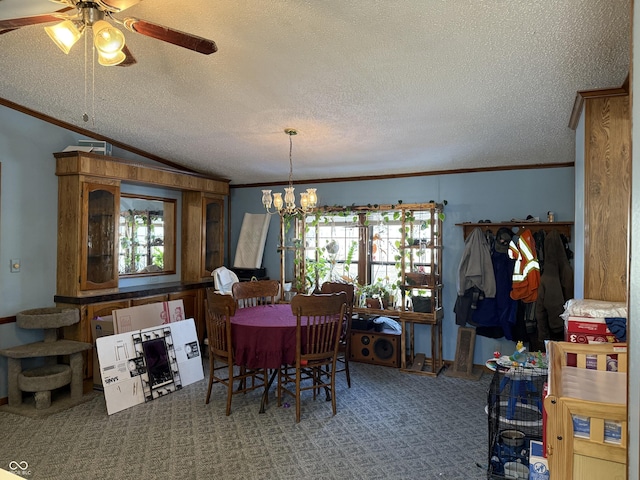 dining area featuring a textured ceiling, ceiling fan with notable chandelier, carpet floors, vaulted ceiling, and ornamental molding