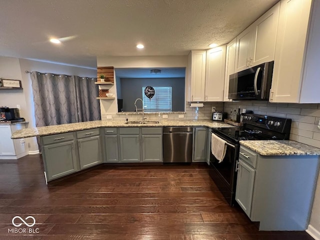 kitchen with a peninsula, dark wood-style flooring, a sink, stainless steel dishwasher, and black electric range oven