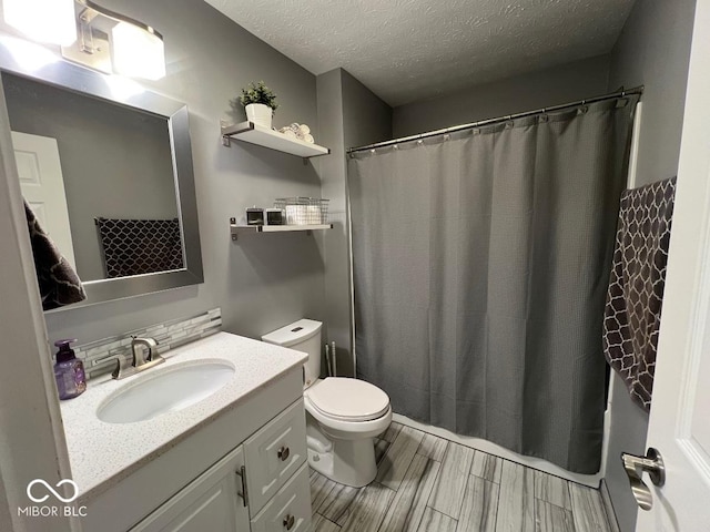 full bath with toilet, vanity, a textured ceiling, and wood finish floors