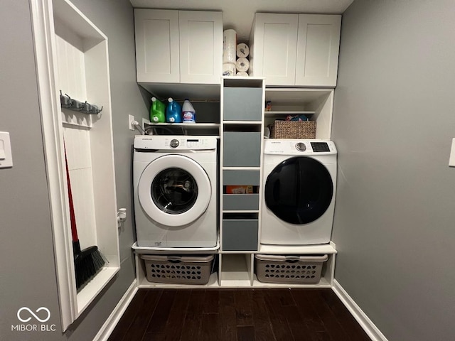 laundry area with cabinet space, baseboards, dark wood-style flooring, and washing machine and clothes dryer