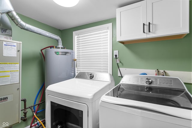 laundry room featuring washer and dryer, cabinet space, and water heater