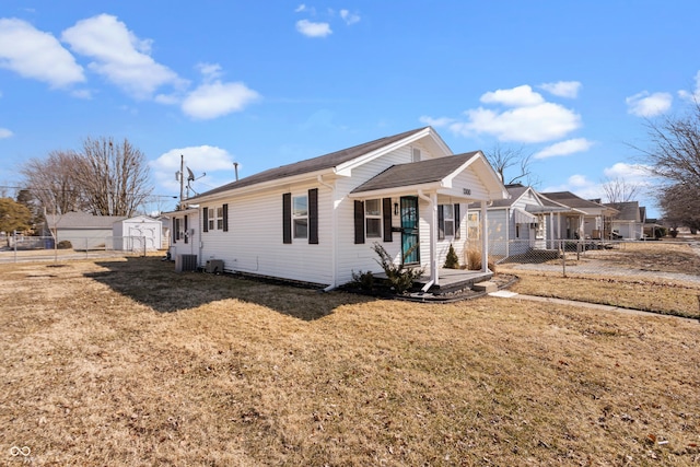 view of front of home with a front lawn, fence, and central air condition unit