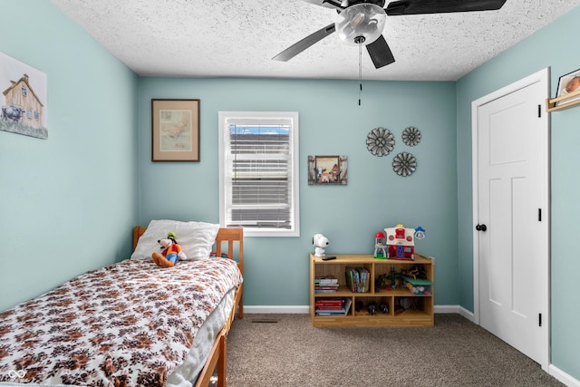 bedroom featuring a ceiling fan, carpet, baseboards, and a textured ceiling