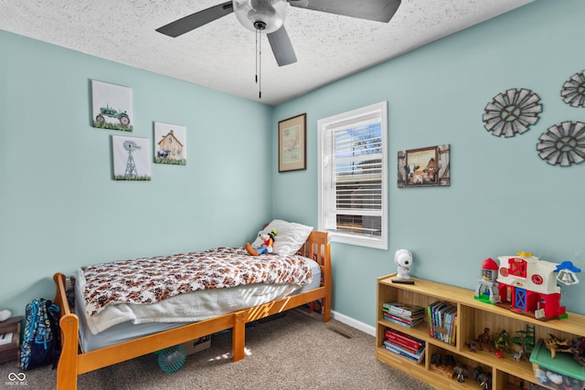 bedroom with a textured ceiling, carpet floors, ceiling fan, and baseboards