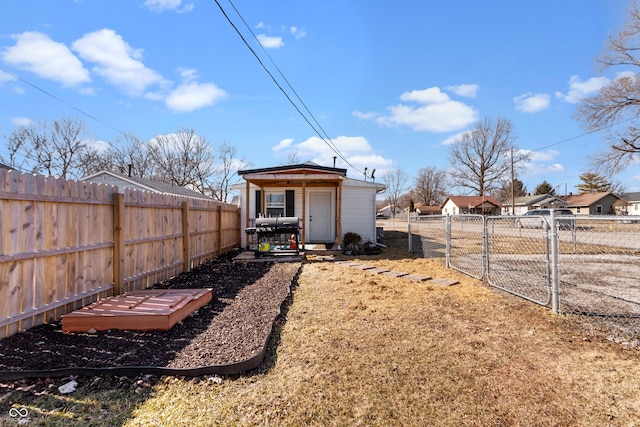 view of yard with an outbuilding, fence private yard, and a gate