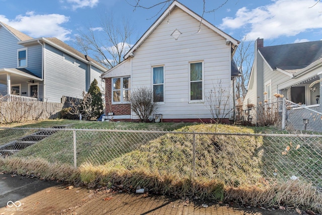 bungalow-style home with brick siding and a fenced backyard