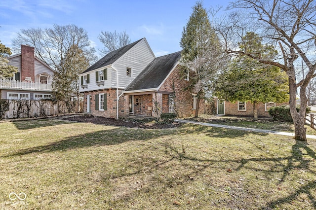 exterior space featuring brick siding, a yard, and fence