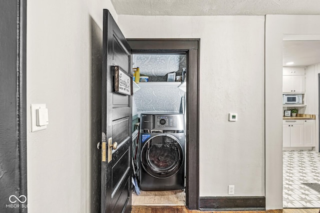 washroom featuring washer / dryer, visible vents, laundry area, and a textured ceiling