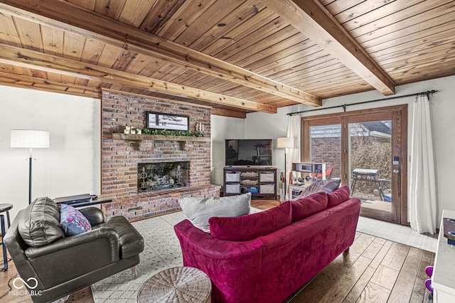 living room featuring hardwood / wood-style floors, beamed ceiling, a brick fireplace, and wood ceiling