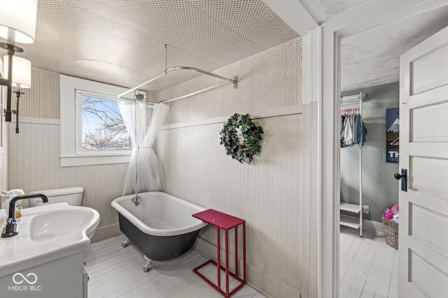 bathroom featuring a freestanding bath, toilet, a shower with shower curtain, vanity, and hardwood / wood-style floors