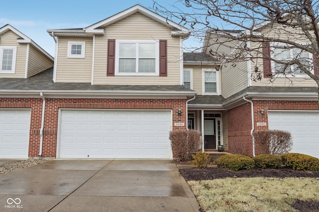 traditional home with driveway, an attached garage, a shingled roof, and brick siding