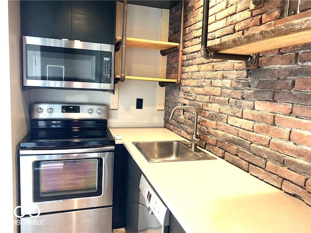 kitchen with brick wall, appliances with stainless steel finishes, light countertops, open shelves, and a sink