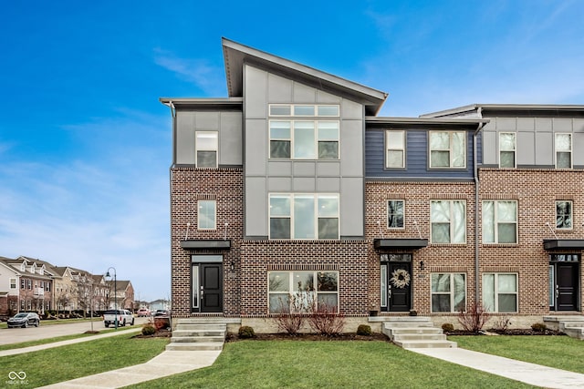 view of front of house with a residential view, brick siding, and a front lawn