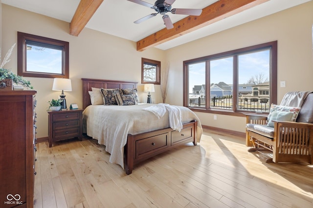 bedroom with light wood-type flooring, ceiling fan, baseboards, and beam ceiling