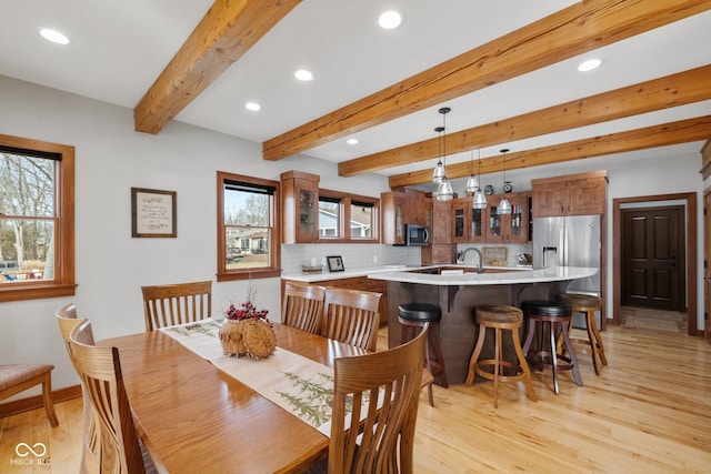 dining area featuring light wood-style floors, baseboards, beamed ceiling, and recessed lighting