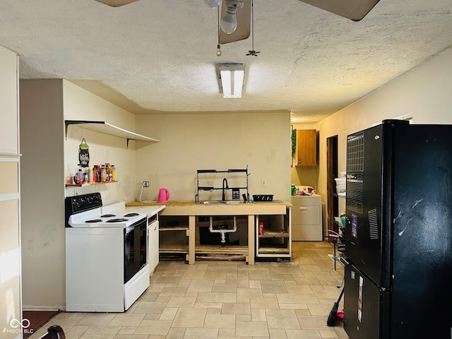 kitchen featuring white range with electric cooktop, washer / clothes dryer, freestanding refrigerator, a sink, and a textured ceiling