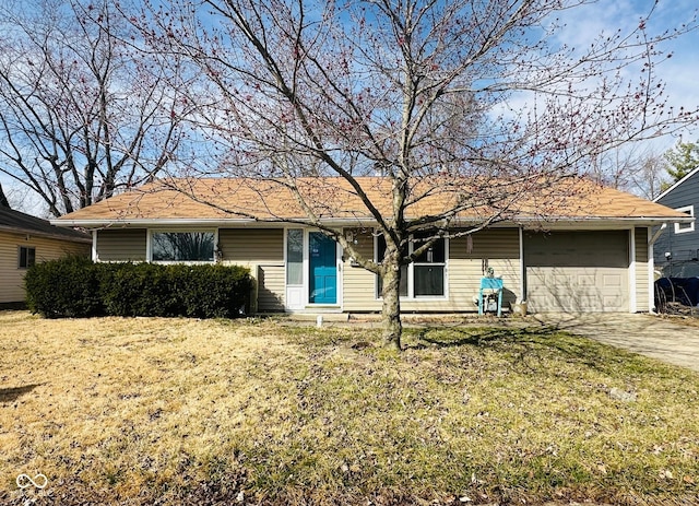 ranch-style house featuring a front lawn, an attached garage, and driveway