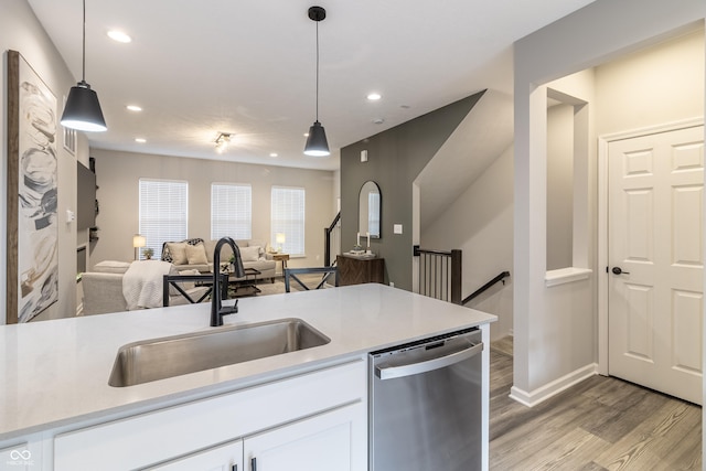 kitchen featuring a sink, white cabinets, light countertops, and dishwasher